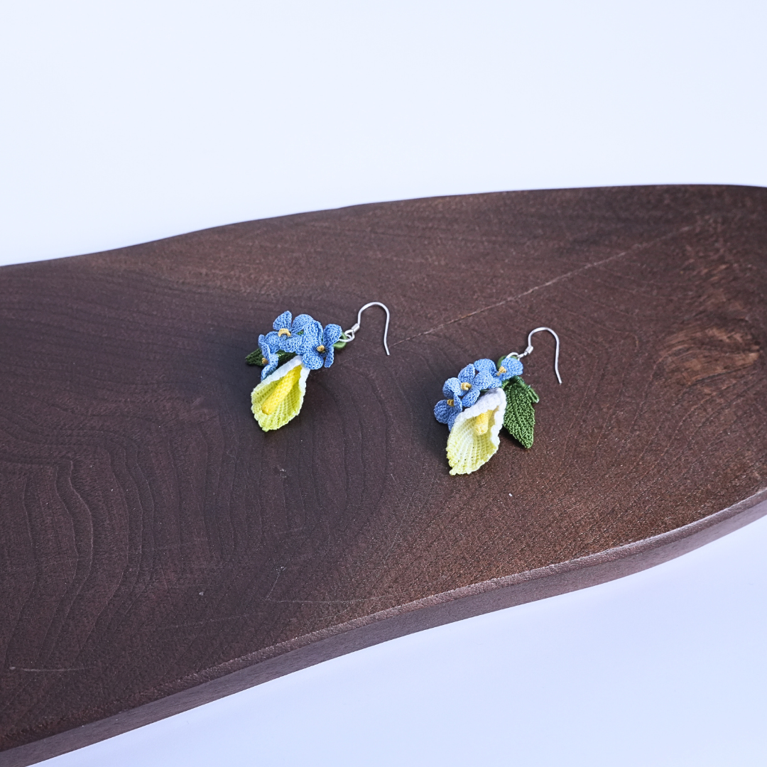 Micro crochet floral earrings displayed on wooden surface, natural handmade style
