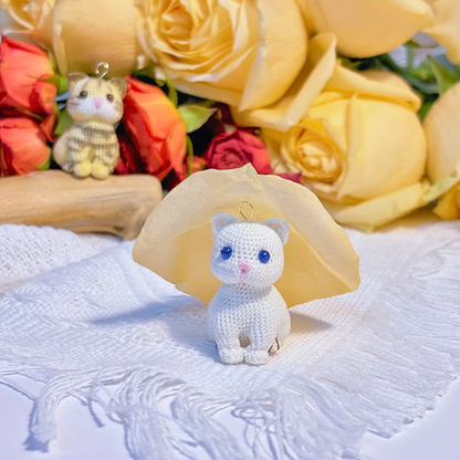 unpainted squat cat micro crochet charm base with sky blue eyes sitting on table, front view