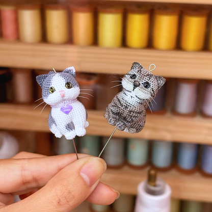 close up of two micro crochet custom cat charms showing detailed fur patterns and bright eyes