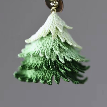 Close-up detail of handmade micro crochet Christmas tree earrings showing fine lace thread work.
