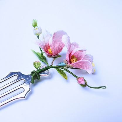 Close-up of a handmade micro crochet magnolia hair comb with pink magnolia flowers and small floral details