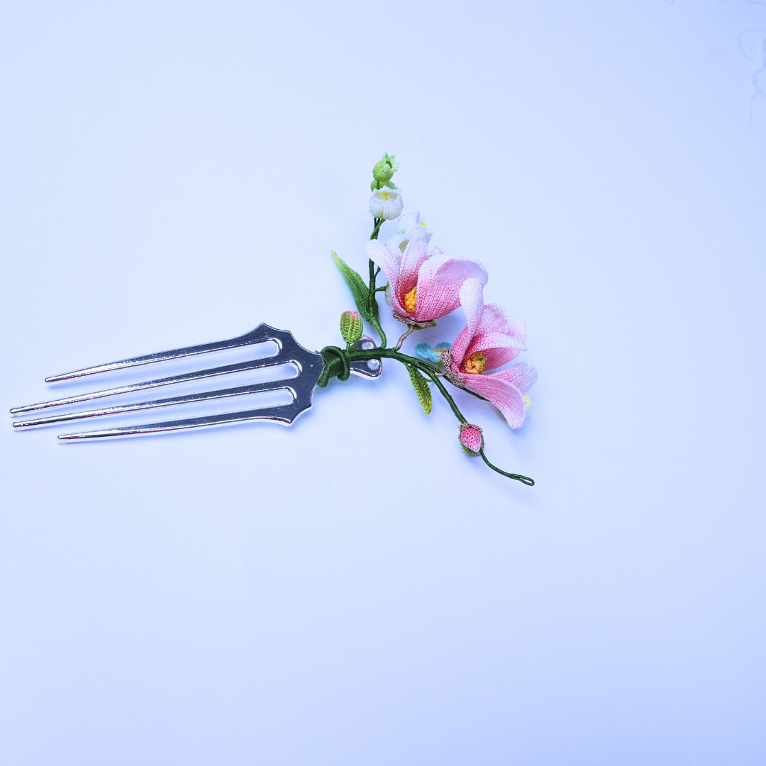Micro crochet magnolia hair comb with pink flowers and small white blossoms on a metal comb base