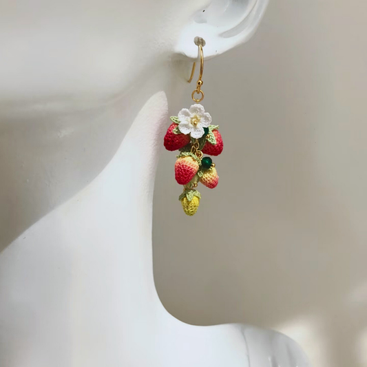 Long micro crochet strawberry earrings worn on ear, lightweight boho-inspired berry pair