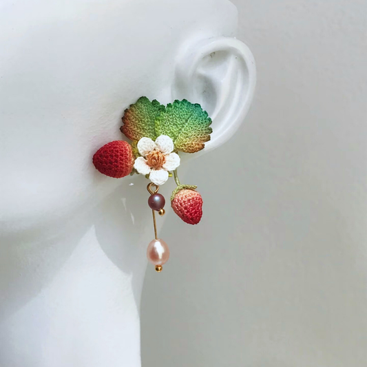 Short micro crochet strawberry stud-style earrings on ear, dainty berry jewelry for everyday wear