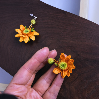 hand holding tiny micro crochet sunflower earrings